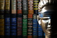 Face of Lady Justice (Symbol of Justice) with stack of legal text books