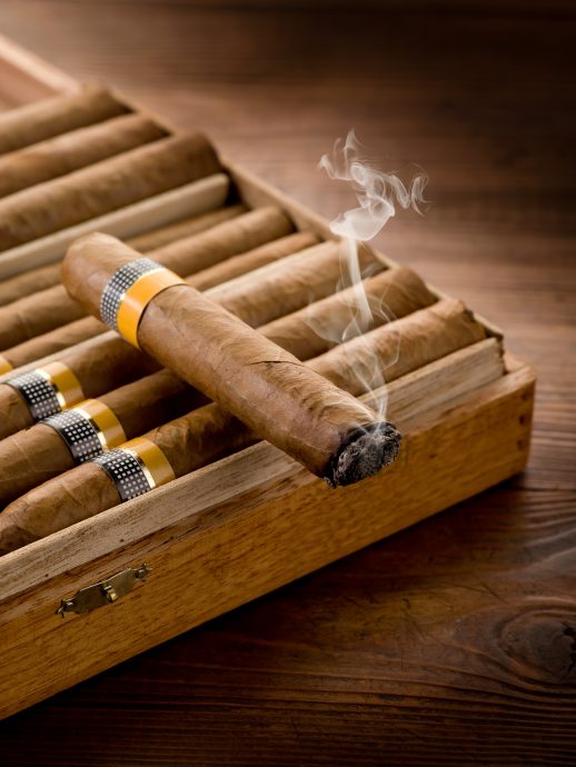 smoking cuban cigar over box  on wood background