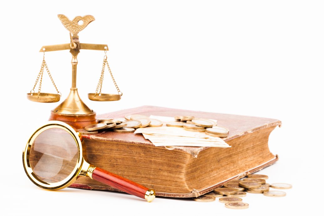 law book, money , magnifying glass and scales of justice
