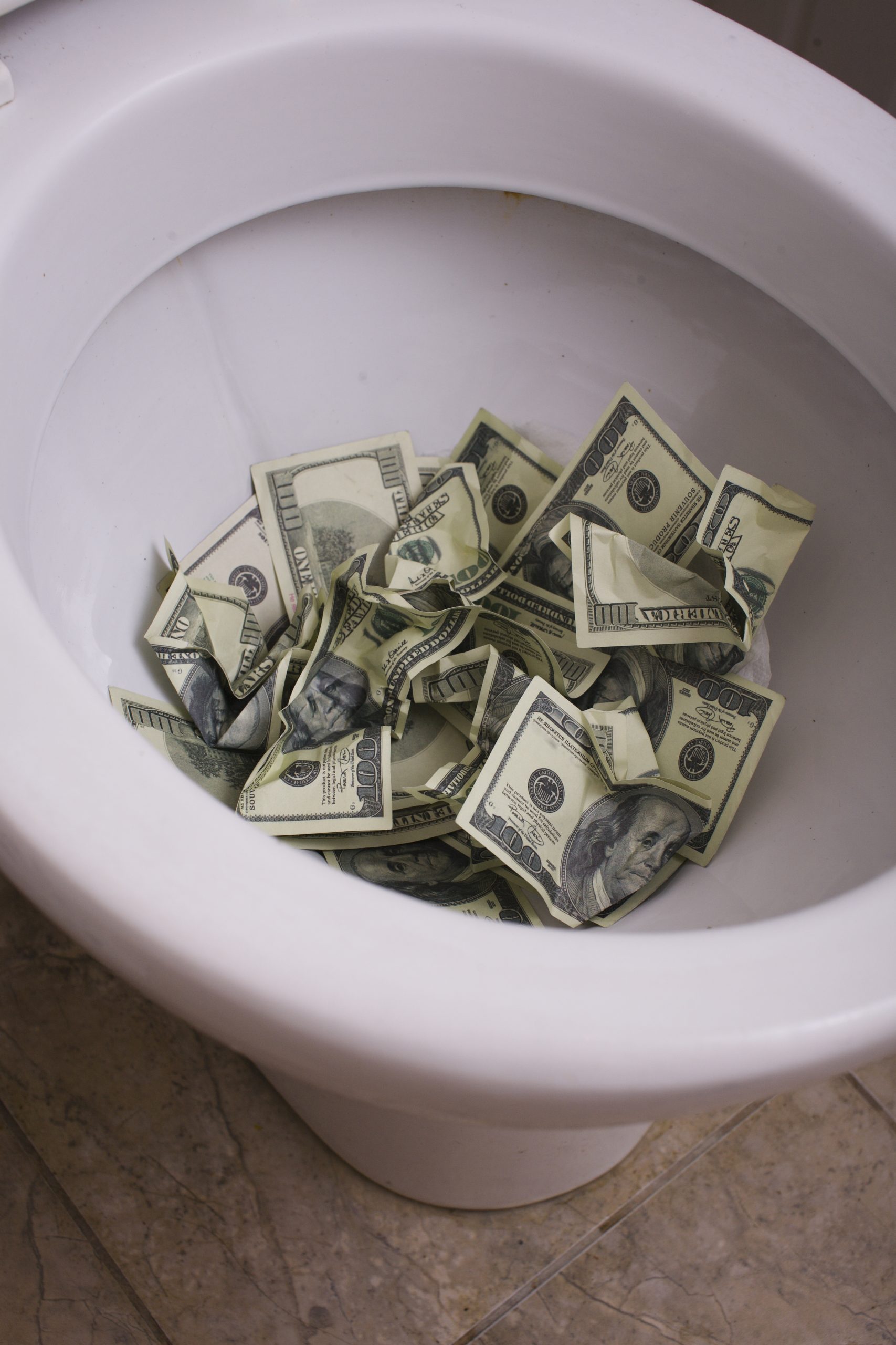 dirty toilet with money close up, lot of cash useless
