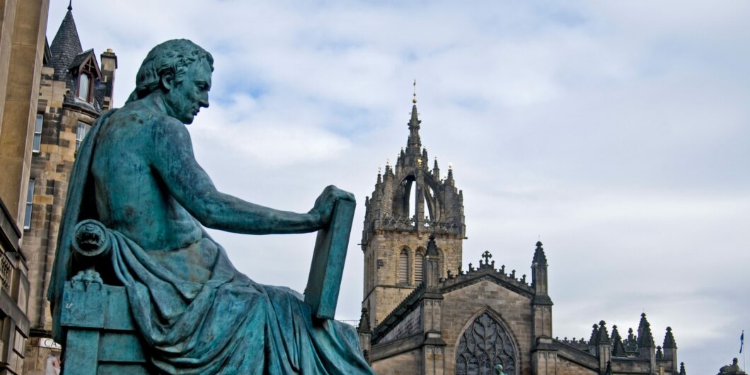 The statue of David Hume on the Royal Mile with St Giles Cathedral Beyond, Edinburgh Lothian Region Scotland  SCO 6076