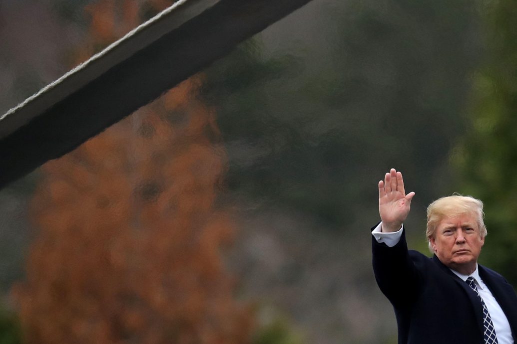 United States President Donald J. Trump waves to journalists as he boards Marine One on departure from Walter Reed National Military Medical Center following his annual physical examination January 12, 2018 in Bethesda, Maryland. Trump will next travel to