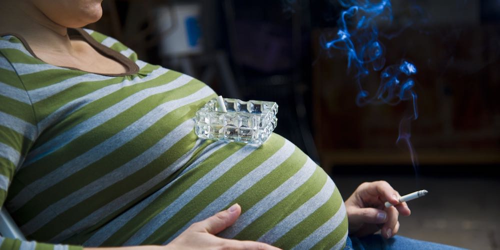 Pregnant woman smoking a cigarette.