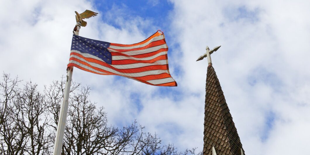American flag flying next to a church steeple