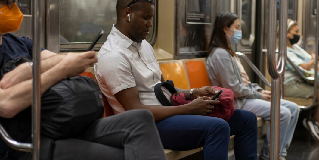 People on their phones on subway_shutterstock_2259222103